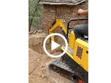 小型挖掘机在农村墙边挖坑